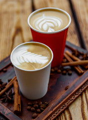 Two cups of cappuccino coffee with latte art on woden table background