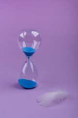 hourglass measuring the time  on a purple background