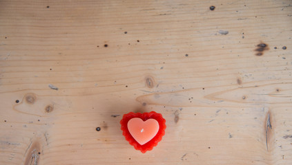 Heart shaped candle on wooden table