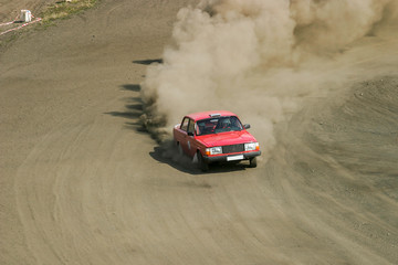Fototapeta na wymiar Rally car skidding on a dusty gravel road