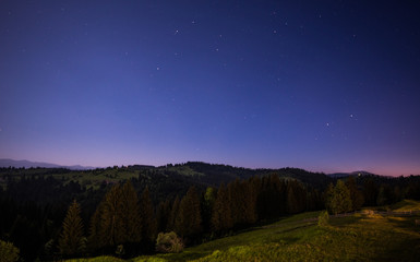 Obraz na płótnie Canvas Mesmerizing starry night view of green hills
