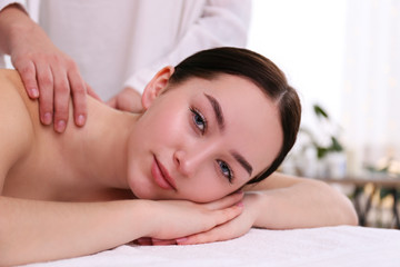 Fototapeta na wymiar Portrait young beautiful woman lying on the massage table in spa wellness salon. Beauty and health procedures for women concept. Close up, copy space, background.