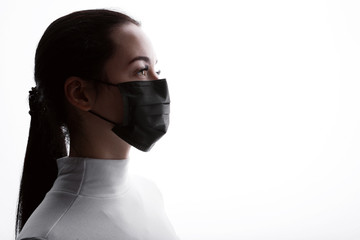 Young woman in protective respirator. Female wearing medical mask. Free space for text. White...