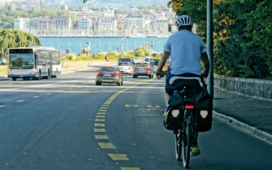 Naklejka premium Man on bicycle on the road in Geneva, Switzerland.
