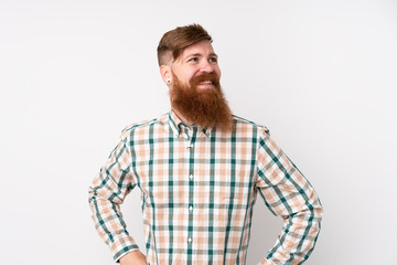 Fototapeta premium Redhead man with long beard over isolated white background posing with arms at hip and smiling