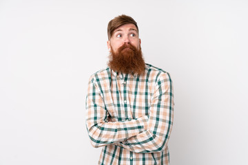 Obraz premium Redhead man with long beard over isolated white background making doubts gesture while lifting the shoulders
