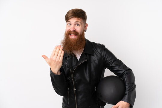 Redhead man with long beard holding a motorcycle helmet over isolated white background inviting to come