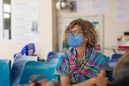 Caucasian Woman Wearing Sanitary Mask Indoors While Traveling In Vietnam. Tourist In Waiting Room With Medical Mask Protection Against Risk Of Chinese Pneumonia Virus Epidemy In Asia