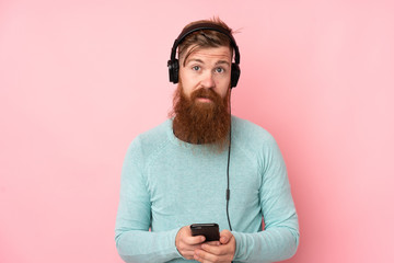 Redhead man with long beard over isolated pink background