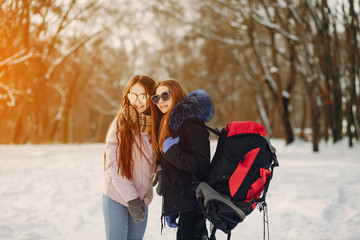 two young friends are walking in the winter snow-covered forest