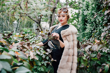 a gorgeous woman in a fur cape is surrounded by green ivy on her head a tiara, a bead hairstyle...