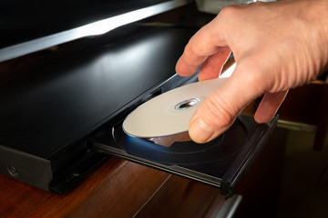 hand holding dvd insert to dvd player