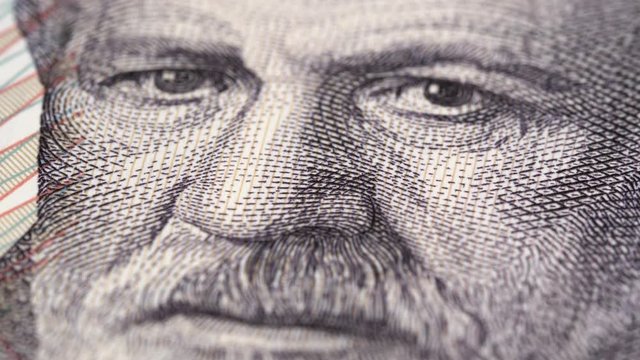 Sigmund Freud portrait on Austria 50 schilling banknote rotating. Austrian neurologist and the founder of psychoanalysis. Low angle, macro. 4K, 422 10 bit