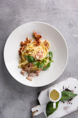 The concept of Italian cuisine. Carbonara paste on a white plate on a light background. Background image, copy space