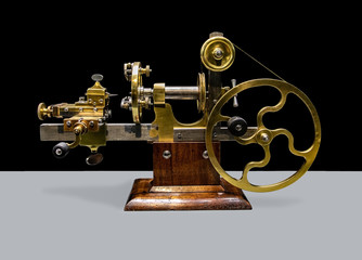 A ancient precision Lathe from 19th century, on black and white background. A historic machinery for processing clock mechanisms.