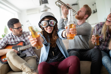 Group of young friends having fun together and playing in music band