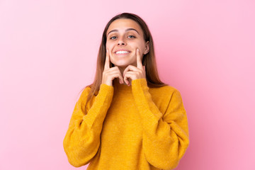 Teenager girl with yellow sweater over isolated pink background smiling with a happy and pleasant expression