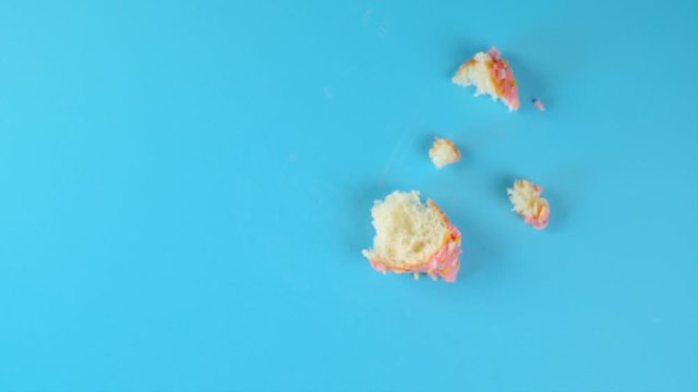 Stop motion creative concept video animation donut bite on blue background .
