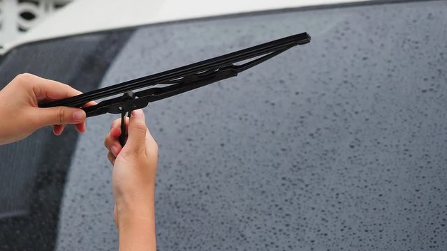 The woman's hand remove the old wiper of the car, Rainy season should always be changed or maintained by car wipers, For driving safety.