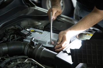Mechanic inspect and replace car battery at garage