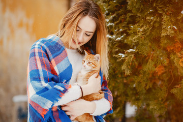 Fashion girl in a winter city. Lady with little cat