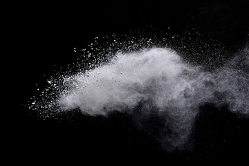 Freeze motion of white color powder exploding on dark background. 