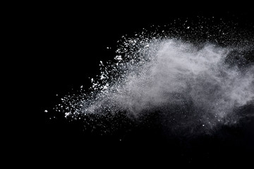 Freeze motion of white color powder exploding on dark background. 