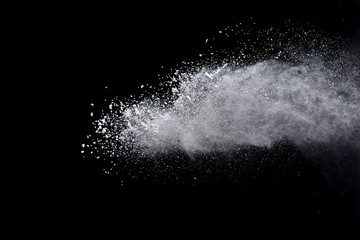 Freeze motion of white color powder exploding on dark background. 