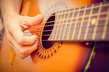 Fototapeta premium man plays a brown guitar in close-up