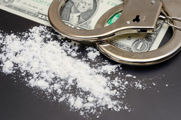Handcuffs, money and cocaine drugs on black background close up