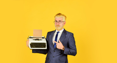 digital business. vintage typewriter. new technology. copy space. successful businessman use retro typewriter. mature man dyed beard hair. professional typist make notes. modern and old technology