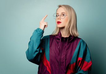 Beautiful woman in 90s sport suit in glasses on blue background