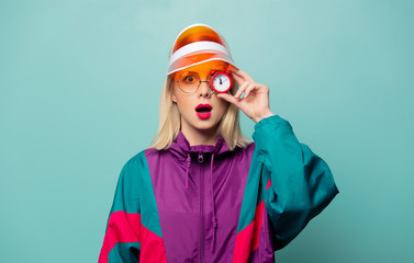 Beautiful woman in 90s sport suit with alarm clock