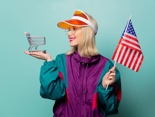 Style blonde woman in 90s sport suit with shopping cart and USA flag