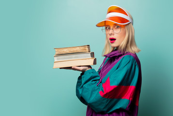 Style blonde woman in 90s sport suit with books
