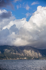 Scenic seascape coastline with cliffs covered with green on cloudy sky background 