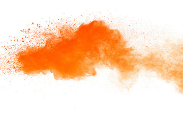 Abstract orange powder explosion. Closeup of orange dust particle splash isolated on white background.