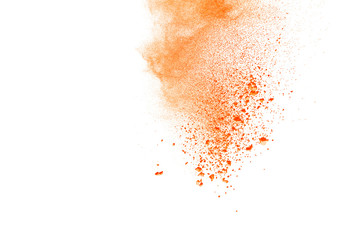 Abstract orange powder explosion. Closeup of orange dust particle splash isolated on white background.