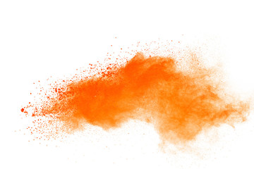 Abstract orange powder explosion. Closeup of orange dust particle splash isolated on white background.