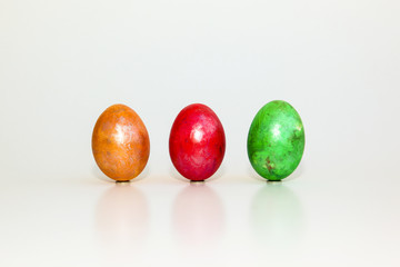 Gelbes, rotes und grünes Ei auf weißem Hintergrund