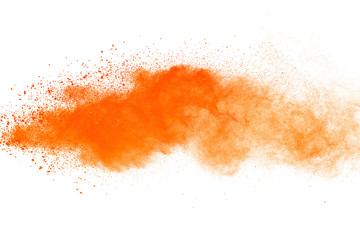 Abstract orange powder explosion. Closeup of orange dust particle splash isolated on white background.