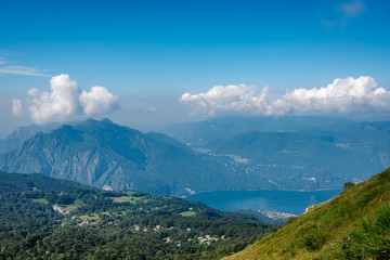 Panoramic views from above to Lake Como and the surrounding mountains at sunny summer day, province of Lecco, Lombardy, northern Italy.