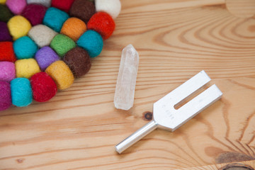 Hand holding a tuning fork and crystal stone  .