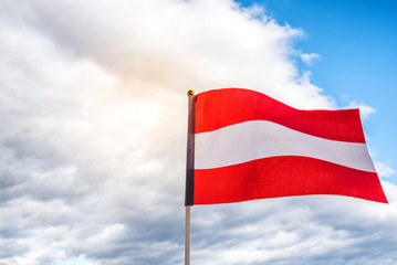 Fototapeta na wymiar Flag of Austria and cloudy sky background