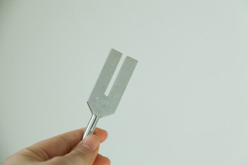 Hand holding a tuning fork .