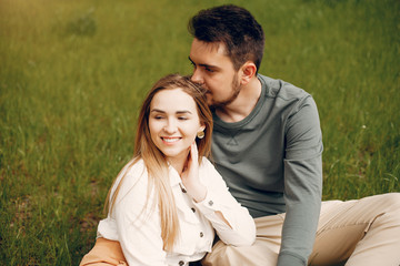 Cute couple in a park. Lady in a white blouse. Guy in a green sweater