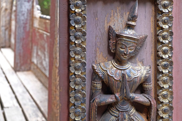 Detailed view of a wooden statue at a local Buddhist temple in Mandalay, Myanmar