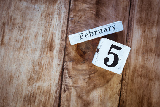 February 5th. Day 5 of February month, white calendar blocks on vintage wooden table background. Winter time. Empty space for text.