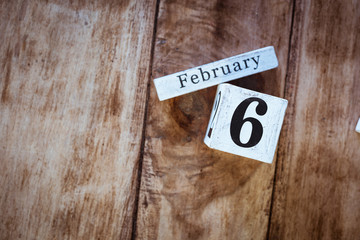 February 6th. Day 6 of February month, white calendar blocks on vintage wooden table background. Winter time. Empty space for text.