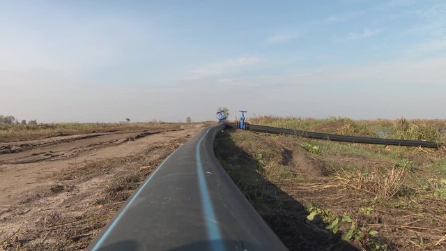 Environmental problem. Cleaning the bottom of the reservoir from non-consolidated silt sediments. Sand mining. Blue butterfly valve on floor and PE. black pipe for raw water pump